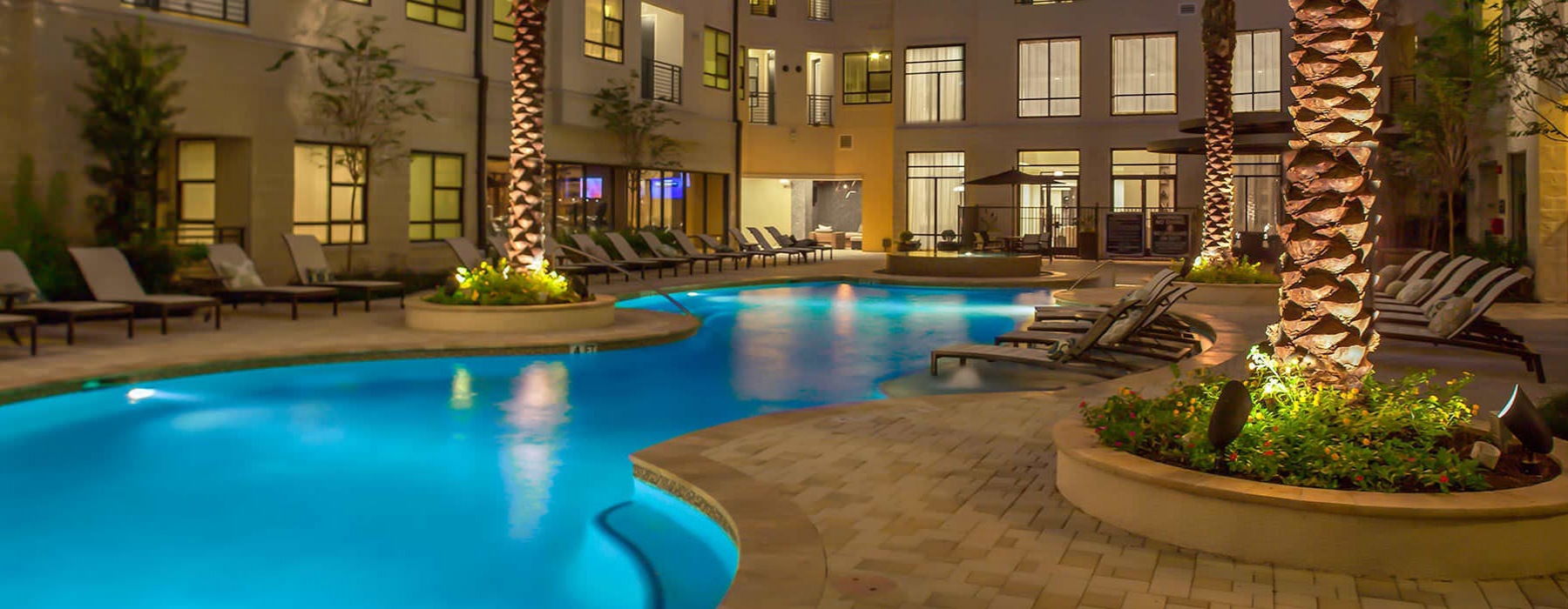 resort style swimming pool lit at night