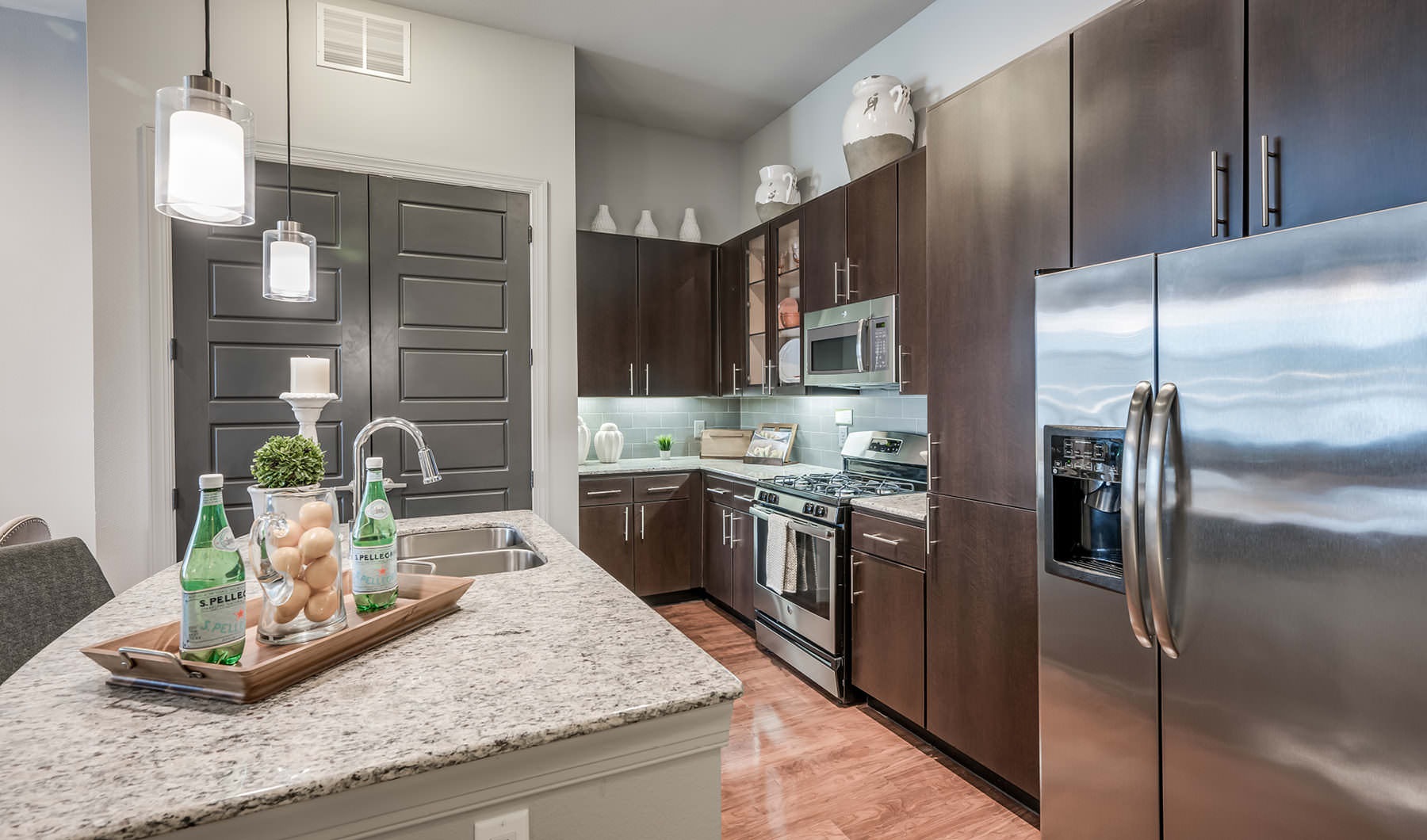 Living Begins Here Under Cabinet Lighting in kitchen and pendant lights over island